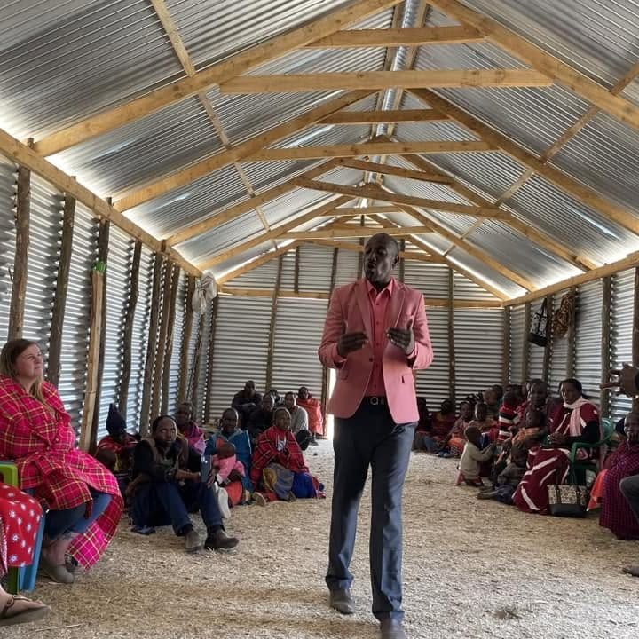 A pastor preaching to a seated congregation inside a newly built village church